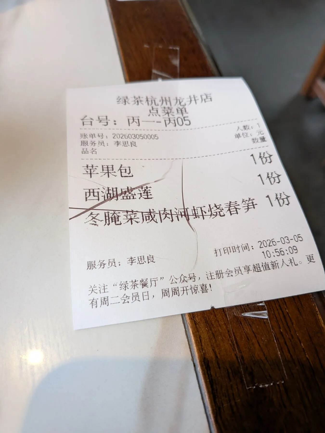 Waiter using his ink-covered nail to strike through the served dishes